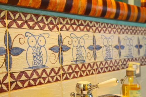 a tile wall with owls painted on it at Casa Nobile in Tovo San Giacomo