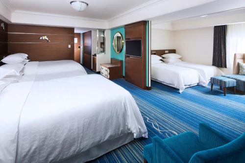 a hotel room with two beds and a couch at Sheraton Grande Tokyo Bay Hotel in Urayasu