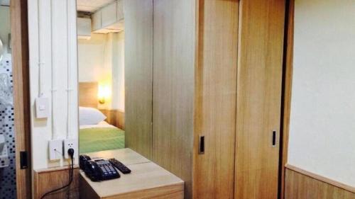 um quarto com uma cama e um telefone numa secretária em Sukhumvit 20 Guest House em Bangkok