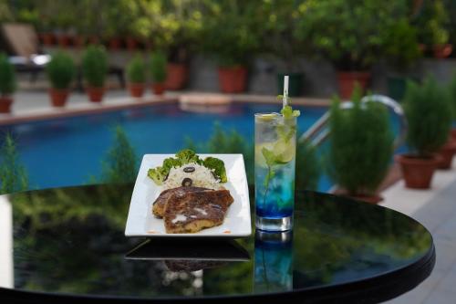 a plate of food on a table with a drink at IRA By Orchid Bhubaneswar in Bhubaneshwar
