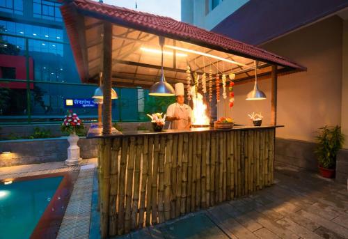 a man standing at a bar next to a swimming pool at IRA By Orchid Bhubaneswar in Bhubaneshwar