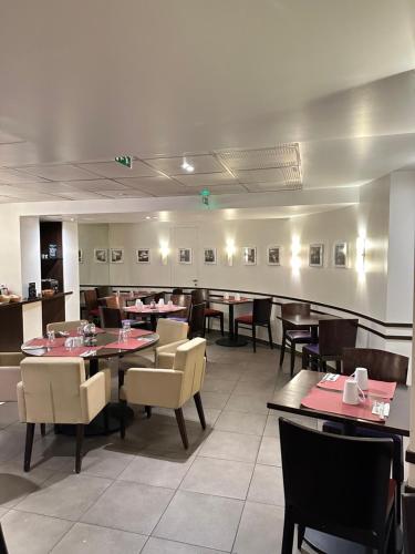 une salle à manger avec des tables et des chaises dans un restaurant dans l'établissement Hôtel Du Centre Annemasse, à Annemasse