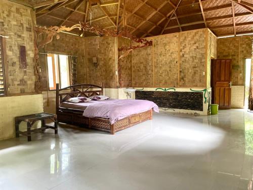 1 dormitorio con 1 cama en el centro de una habitación en Batu Kapal Lodge, en Bukit Lawang