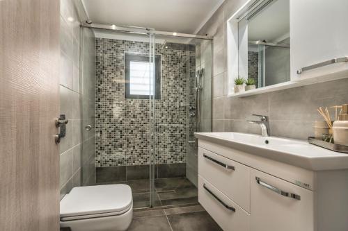 a bathroom with a toilet and a sink and a shower at Villa Debora in Zakynthos Town