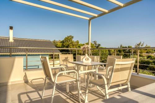 a patio with a table and chairs on a balcony at Villa Debora in Zakynthos Town