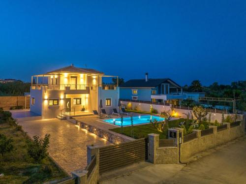 a house with a swimming pool at night at Villa Debora in Zakynthos Town