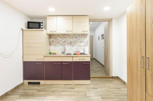 uma cozinha com armários roxos e um corredor em Marinianis Premium Apartment em Zagreb
