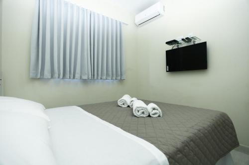 a bedroom with a bed with two towels on it at Rivello Apart Hotel in Sete Lagoas