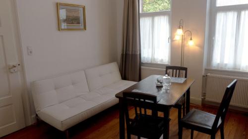 a living room with a white couch and a table at Schöne Ferienwohnung am nordwestlichen Rand des Taunus in Hünfelden