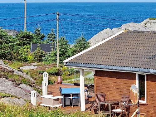 a cabin with a table and chairs and the ocean at 6 person holiday home in skudeneshavn-By Traum in Skudeneshavn