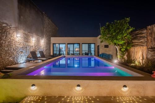 uma piscina no meio de uma casa à noite em La Casa del Jaguar em Mérida