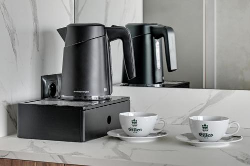 two coffee makers and two cups on a counter at GRANO HOTEL Solmarina in Wiślinka