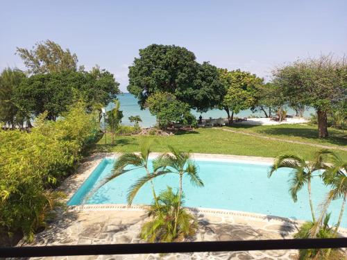 a swimming pool with the ocean in the background at Sonrisa Villas in Diani Beach