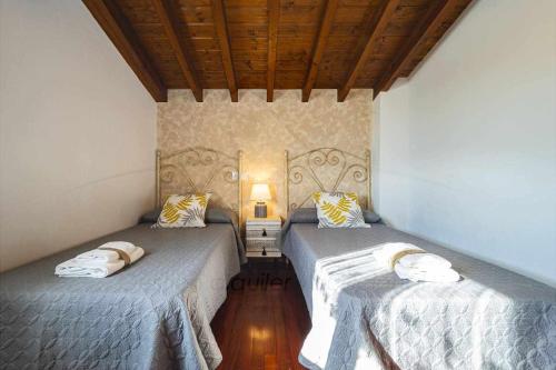 dwa łóżka siedzące obok siebie w pokoju w obiekcie Casa Azul De Perlleces w mieście Cangas de Onís