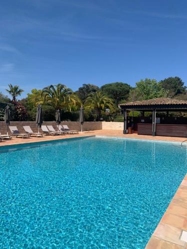 une grande piscine avec des chaises et un gazebo dans l'établissement Maison classée sur le Golfe de St Tropez, à Saint-Tropez