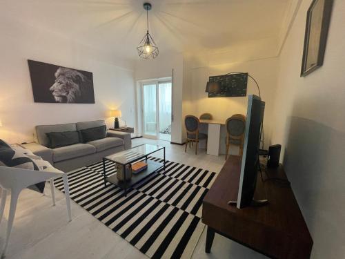 a living room with a couch and a tv at MHouse lease Cascais Spacious 3 BR Family next center in Alcabideche