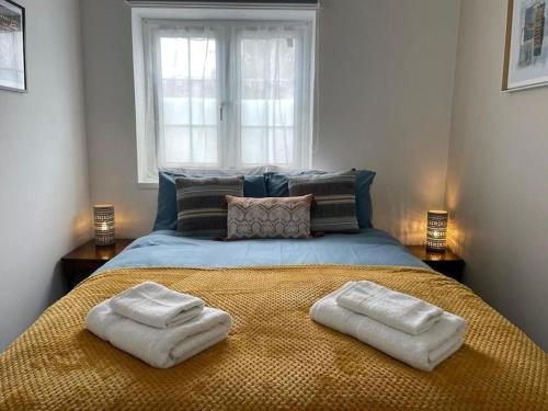 a bedroom with a bed with two towels on it at Cozy Retreat in Luton in Luton