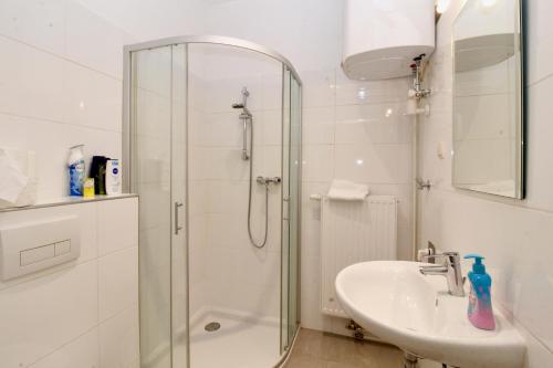 a white bathroom with a shower and a sink at Graz Central APT sleeps 4 in Graz