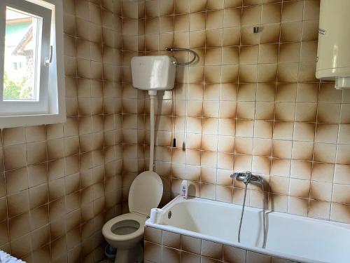 La salle de bains est pourvue de toilettes et d'une baignoire. dans l'établissement Kobran, à Kuršumlija