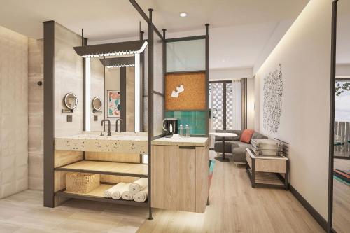 Elle comprend un salon et une salle de bains pourvue d'un lavabo. dans l'établissement Aloft Bali Kuta at Beachwalk, à Kuta