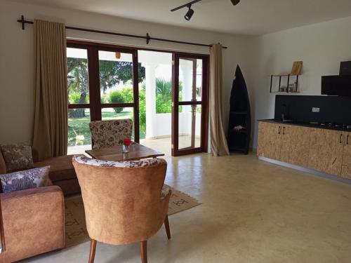 uma sala de estar com um sofá e uma mesa em Sonrisa Villas em Praia de Diani