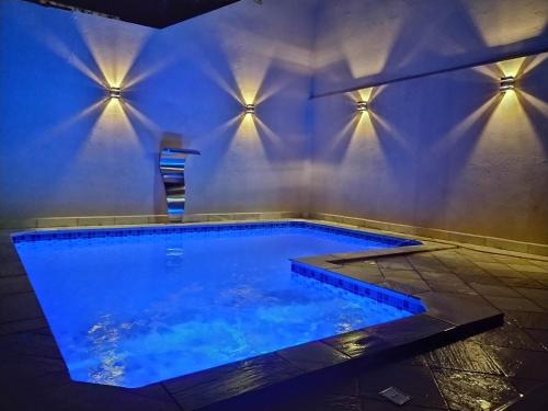 uma piscina com iluminação azul numa casa em Piscina Aquecida, Ar condicionado Casa Inteira,Caminhos da Canastra em São João Batista do Glória