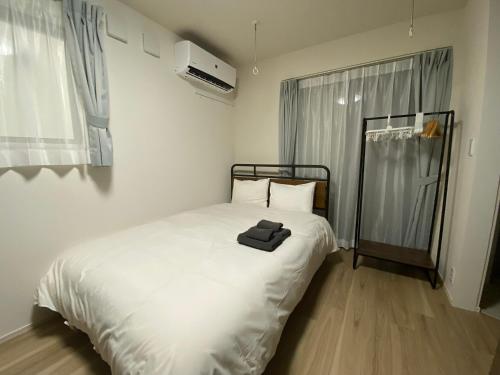 a bedroom with a white bed and a window at EveryNet Shinjuku by Tranova in Tokyo