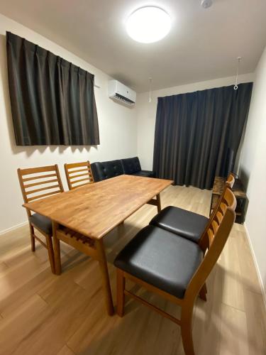 a dining room with a wooden table and chairs at EveryNet Shinjuku by Tranova in Tokyo