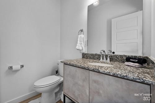 a white bathroom with a toilet and a sink at Pacific Palace-NEW 2bed 2 5bath Home in Centerton in Bentonville