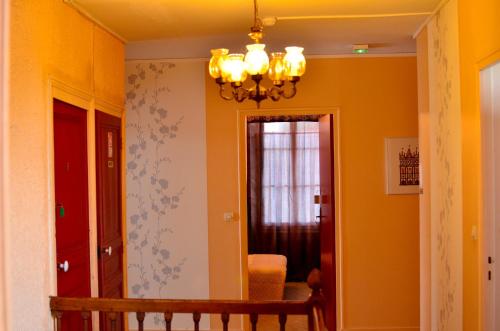 a hallway with yellow walls and a chandelier at Auberge La Croix Blanche in Combreux