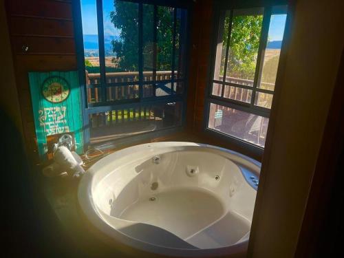 bañera en una habitación con 2 ventanas en Cabin Eretz Ha-Kineret, en Had Nes
