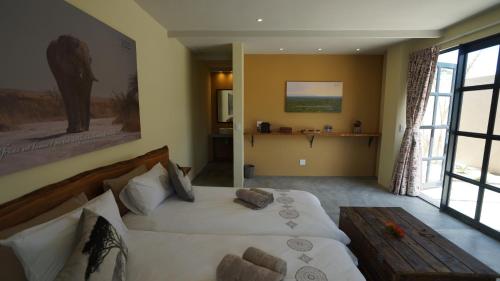 1 dormitorio con cama grande y ventana grande en Stellar Overberg Travellers Lodge, en Napier