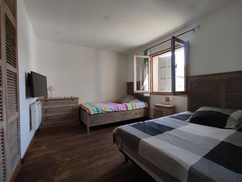 - une chambre avec 2 lits, une télévision et une fenêtre dans l'établissement Appartements équipés 1km plage, à Fos-sur-Mer