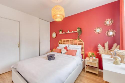 um quarto com uma cama branca e uma parede vermelha em Ohara - Free P - RER C - Netflix - Easy Check-in em Asnières-sur-Seine
