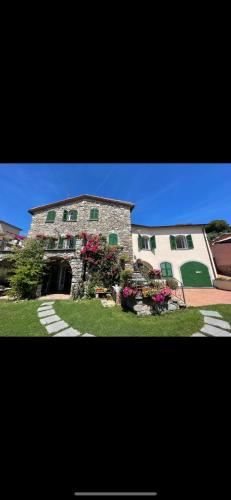 a large stone building with flowers in front of it at IL CASALE DEL MAGRA in Ameglia