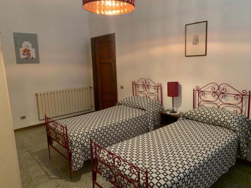Cette chambre comprend deux lits, une table et des chaises. dans l'établissement Casa Pucci, à Pietrasanta