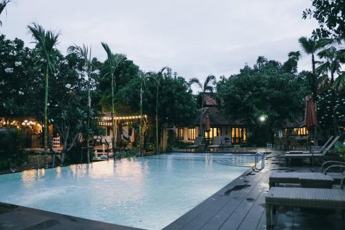 a large swimming pool at a resort at night at Le Baan Thai Boutique Villa in Chiang Mai