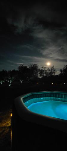 a swimming pool at night with the moon in the sky at Les Gîtes de JueVince in Issac