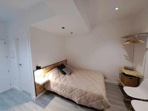 1 dormitorio con 1 cama en una habitación blanca en ACC Serrano 1 aparcamiento cercano, en Jaén