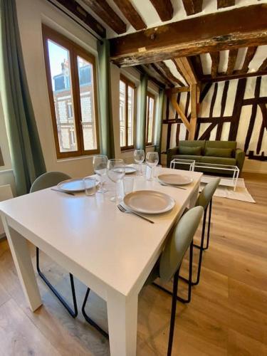 - une table blanche avec des chaises et des verres à vin dans l'établissement L’Eucalyptus, à Rouen