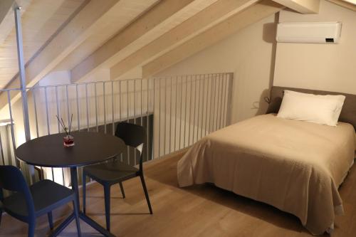 a bedroom with a bed and a table and chairs at Affittacamere Valèt in San Marzano Oliveto