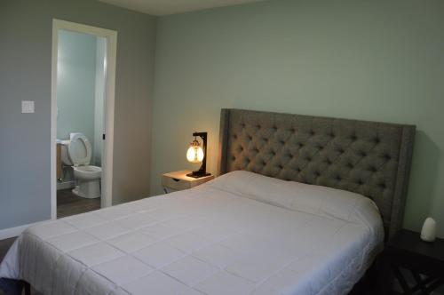 ein Schlafzimmer mit einem großen weißen Bett und ein Badezimmer in der Unterkunft Tranquil and Modern Home 3br in Kenmore