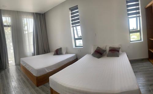 - 2 lits dans une chambre avec 2 fenêtres dans l'établissement Biệt thự - Cafe Path Way, 