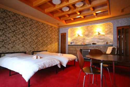 2 camas en una habitación con mesa y sillas en Guest House Gimanchi en Ashoro