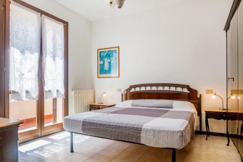 ein Schlafzimmer mit einem großen Bett und zwei Fenstern in der Unterkunft Casa Luz in Giglio Porto
