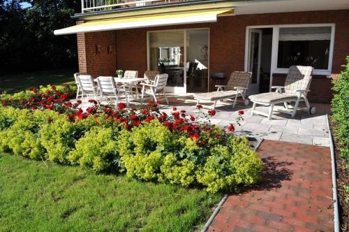 eine Terrasse mit Stühlen und Blumen vor einem Haus in der Unterkunft myOSTSEE Dream Ferienwohnung in Niendorf