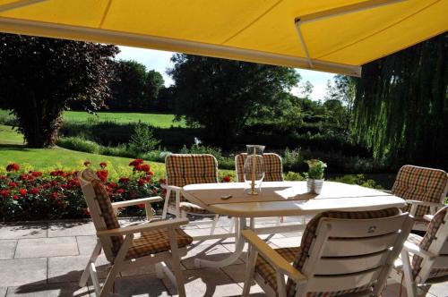 einen Tisch und Stühle unter einem gelben Regenschirm in der Unterkunft myOSTSEE Dream Ferienwohnung in Niendorf