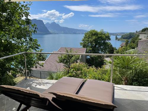 une chaise sur un balcon avec vue sur le lac dans l'établissement Villa Bootsmann mit spektakulärer Seesicht und Badeplatz, à Vitznau