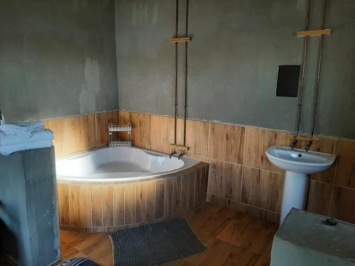 a bathroom with a bath tub and a sink at Perdestal in Oranjeville