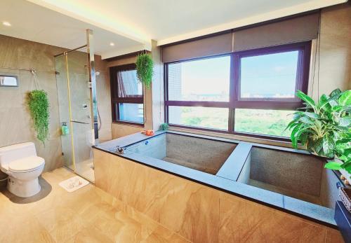 a bathroom with a tub with a shower and a toilet at 文旅海景 in Toucheng